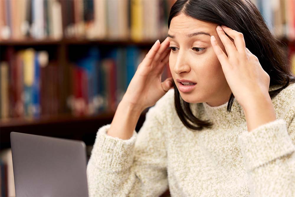 Worried student using a laptop